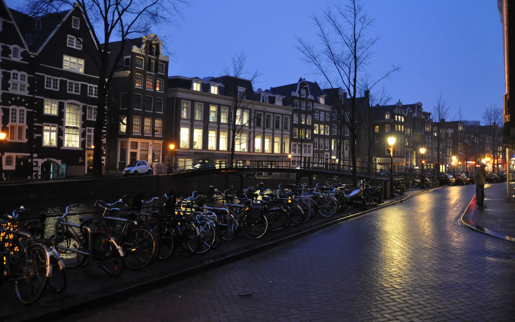 Canal houses and parked bicycles in central Amsterdam at dusk