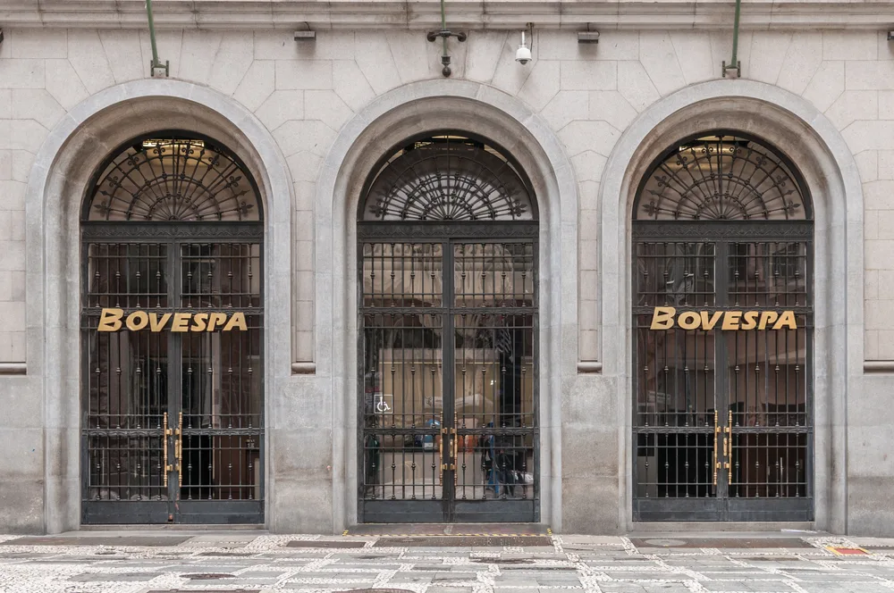 Three arched, wrought-iron doorways in a stone facade, two of them bearing the gold letters 'BOVESPA'.