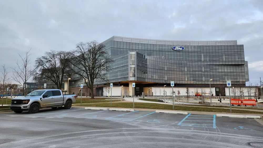 Ford World Headquarters in Dearborn, with an F-150 pickup in front.