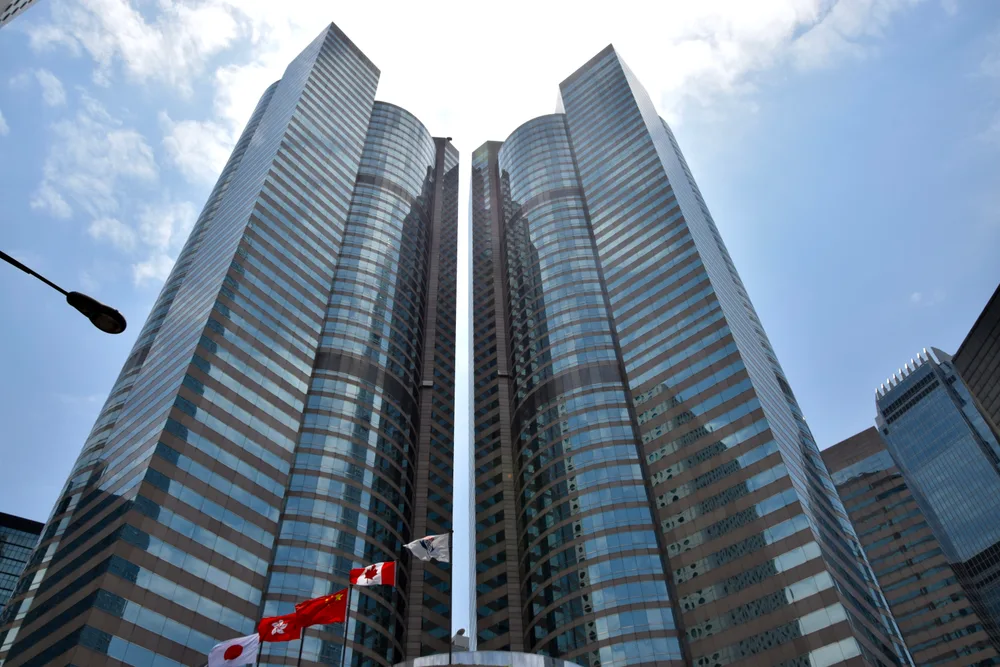 The twin glass towers of Exchange Square seen from below, with flags flying in front.