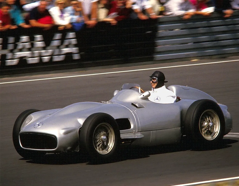 Juan Manuel Fangio driving an exposed-wheel Mercedes-Benz W196 with a 3-litre engine at the Nürburgring in 1986. Later demonstration photograph, not the auctioned chassis.