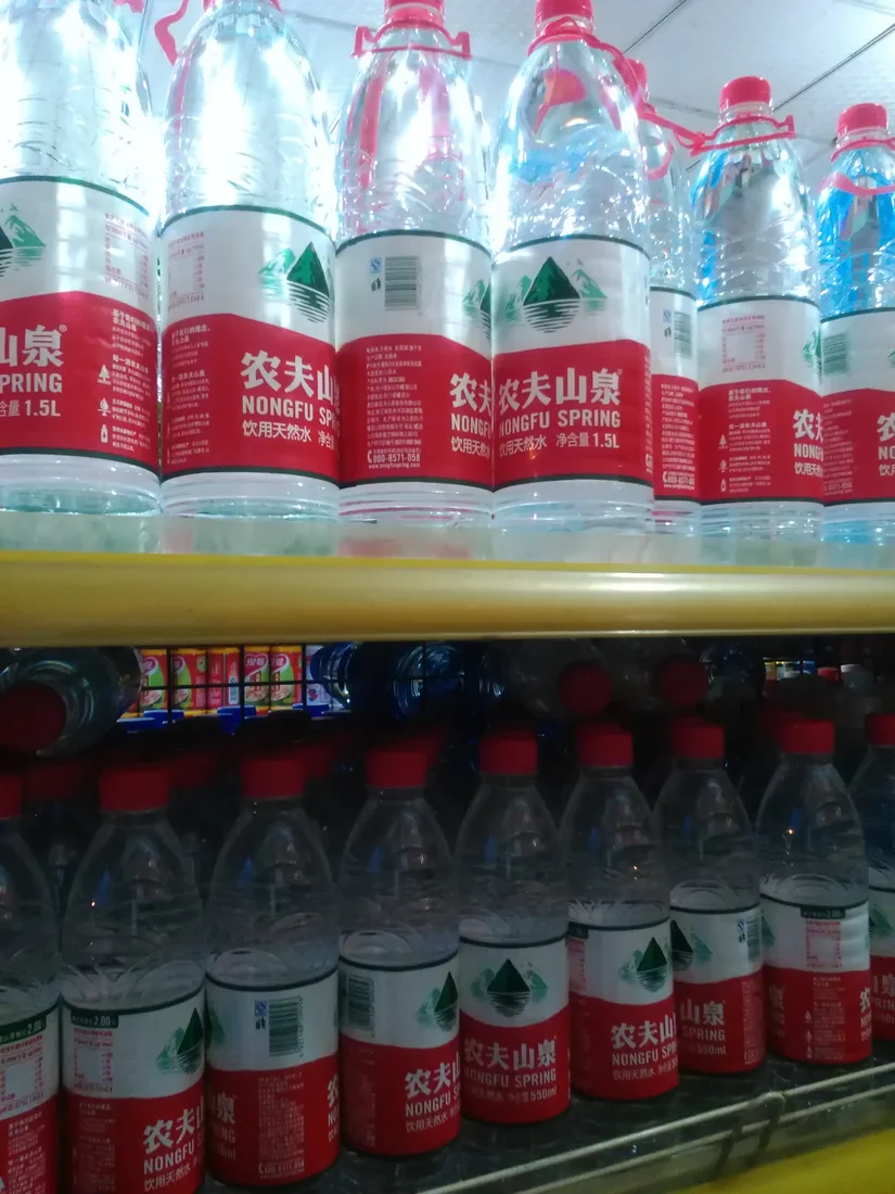 Bottles of Nongfu Spring water on a shop shelf.